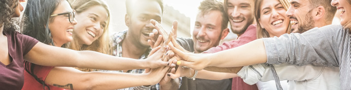 Young happy people stacking hands outdoor - Diverse culture students celebrating together - Youth lifestyle, university, relationship, human resorces, work and friendship concept - Focus on hands